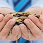 Dos manos están sujetando monedas